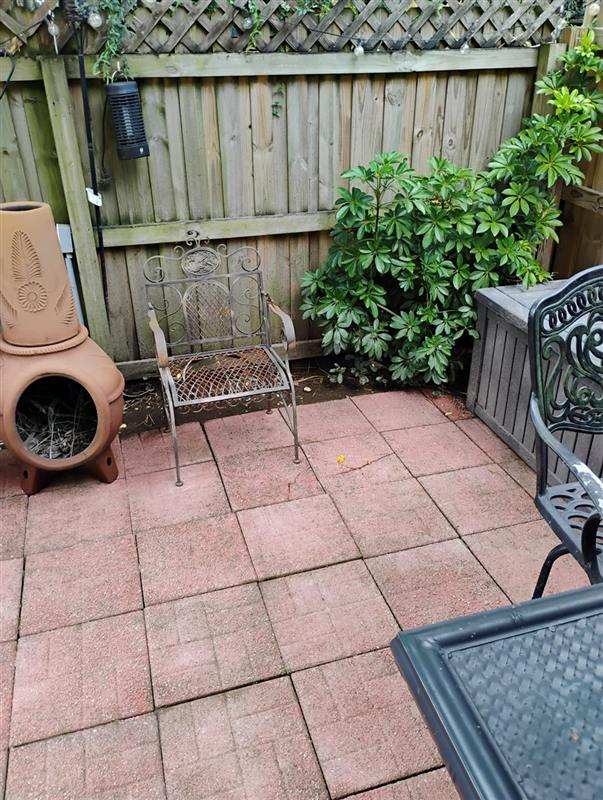 The same paver patio pressure-washed clean, with patio furniture