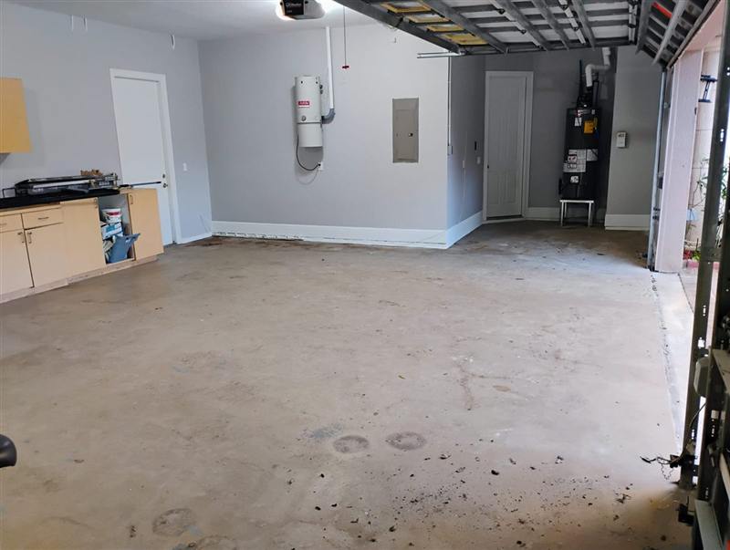 Garage with a bare, stained concrete floor before coating