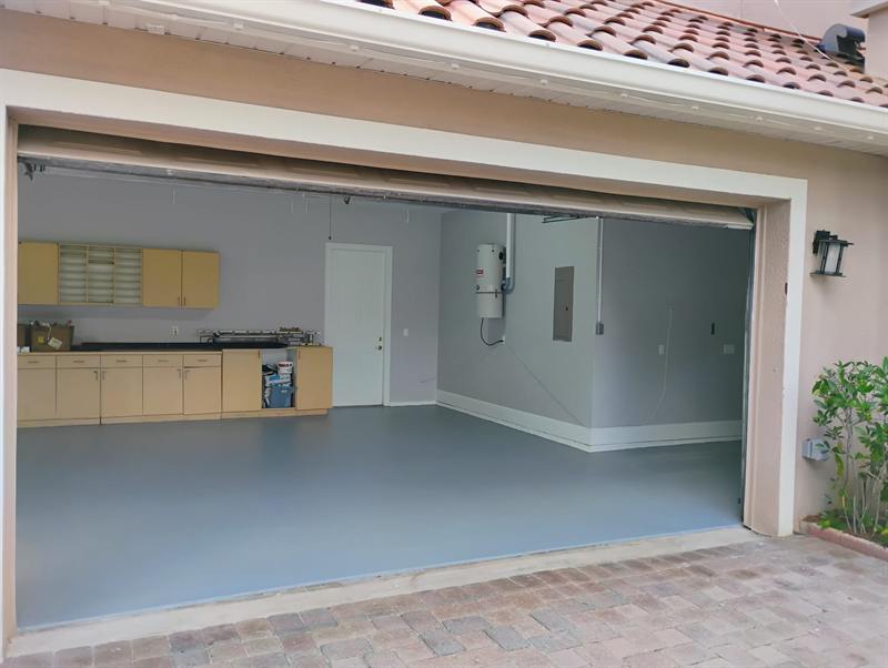 Two-car garage with a smooth gray epoxy floor, seen from the driveway